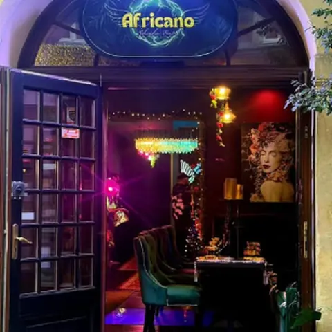 Wejście do Africano — neony i zielone fotele